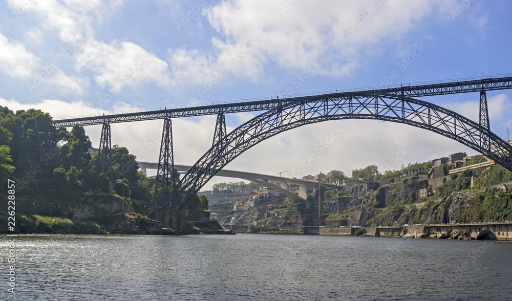 Naklejka premium Maria Pia Bridge over the Douro river, Porto, Portugal. Panoramic view from the water. A great place for tourist trips.
