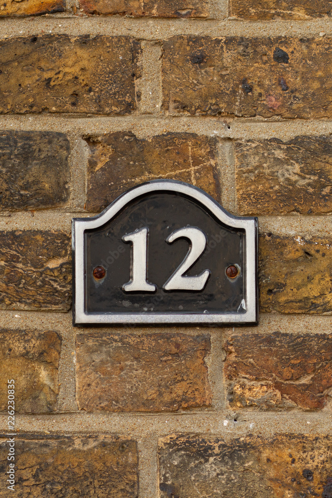 House Number 12 written in white on black enamel House Number 12 written in white on black enamel