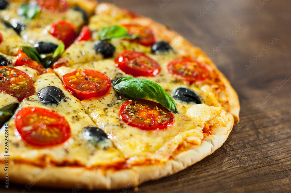 sliced Pizza Margherita or Margarita with Mozzarella cheese, tomato, olive. Italian pizza on wooden background sliced Pizza Margherita or Margarita with Mozzarella cheese, tomato, olive. Italian pizza on wooden background