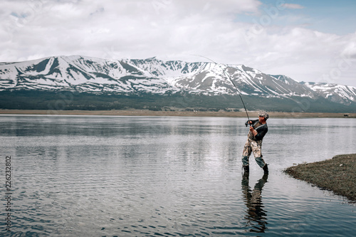 Peaceful fishing at a mountain lakein Mongolia photo