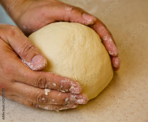 Close-up view of the female hands kneading dough for the homemade cake