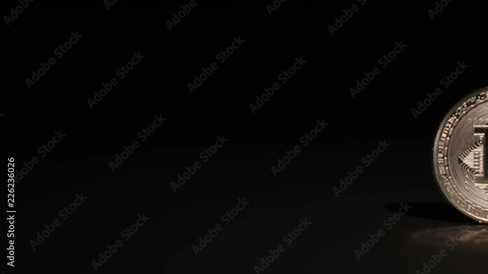 panning along a golden silver and bronze Bitcoin cryptocurrency coin on a black background panning along a golden silver and bronze Bitcoin cryptocurrency coin on a black background