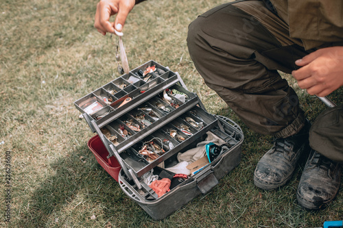 A fisherman selects the right Accessories that he is going to fish with. fishing tackles and fishing gear on on the ground