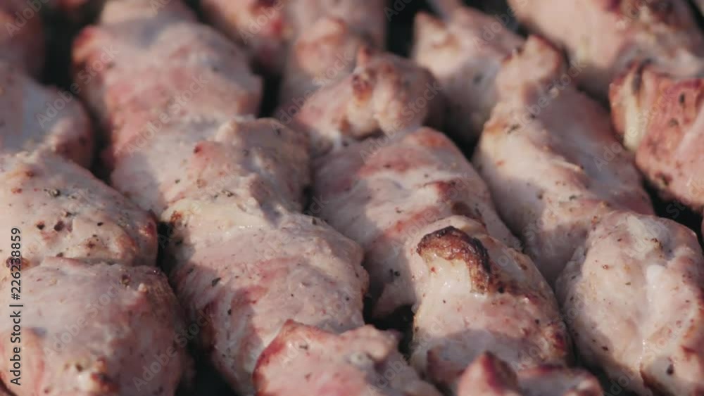 Closeup slow motion cooking pork shashlik on skewers outdoor Closeup slow motion cooking pork shashlik on skewers outdoor