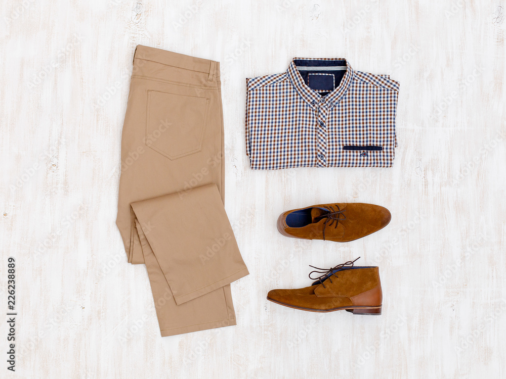 Beige pants, plaid shirt and brown suede shoes. Overhead view of men's  casual outfit on white wooden background. Flat lay, top view. Stock Photo |  Adobe Stock