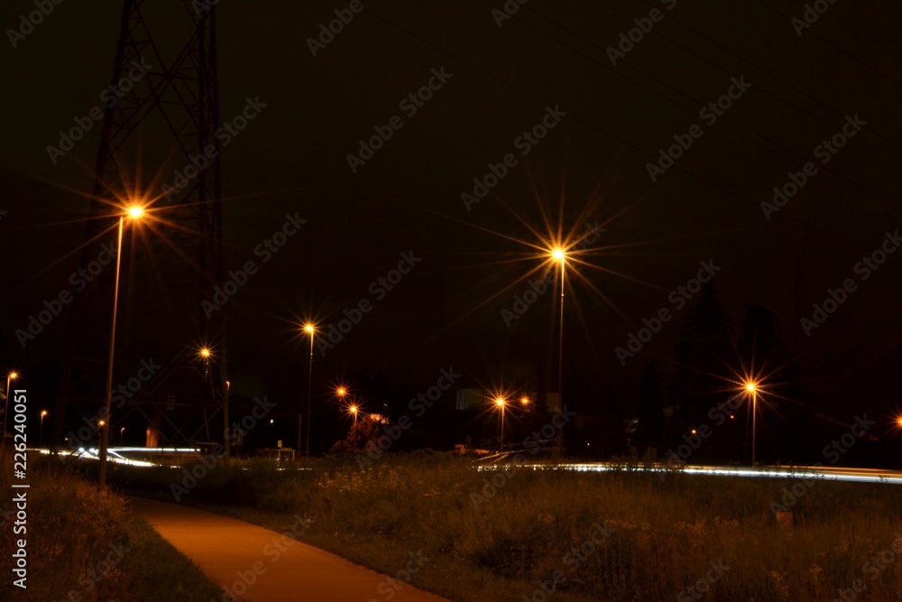 Nighttime photograph of a bicycle lane and a road near Vuntcomplex, Leuven, Belgium.