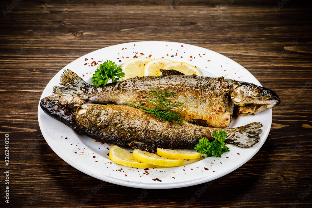 Fish dish - fried fish fillet on wooden table Fish dish - fried fish fillet on wooden table