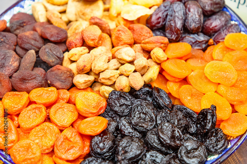 Dried fruits: dried apricots, prunes and others lie on a plate