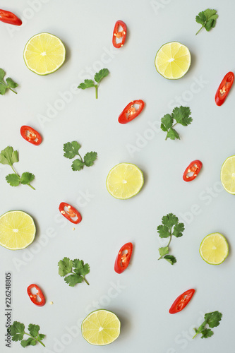 Lime, cilantro and chili on light blue background, top view
