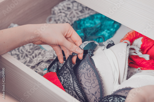 Woman choosing lingerie. Drawers filled with sexy lace lingerie. Textile, Underwear.