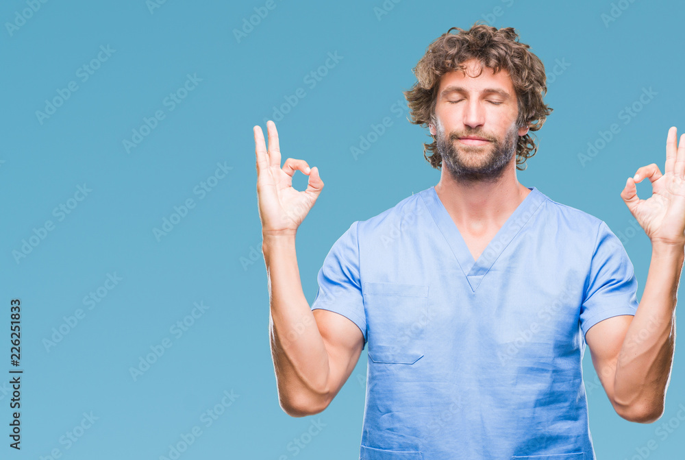 Naklejka premium Handsome hispanic surgeon doctor man over isolated background relax and smiling with eyes closed doing meditation gesture with fingers. Yoga concept.