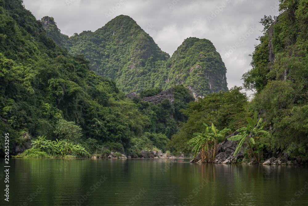 Tropical scenery with mountains along the Red River in Vietnam's Trang An scenic landscape in Southeast Asia