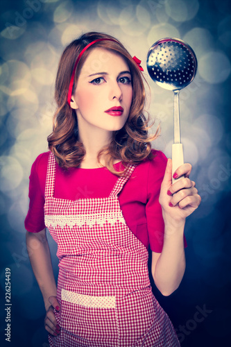 Redhead housewife with soup ladle on bokeh background © Masson