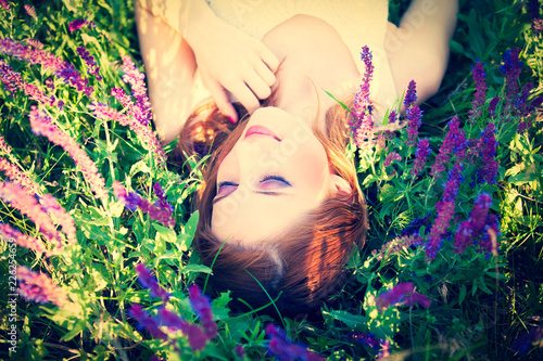 Girl liyng on spring grass and flowers. View above. photo