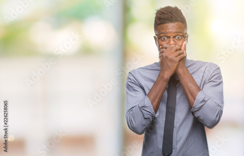 Young african american business man over isolated background shocked covering mouth with hands for mistake. Secret concept.
