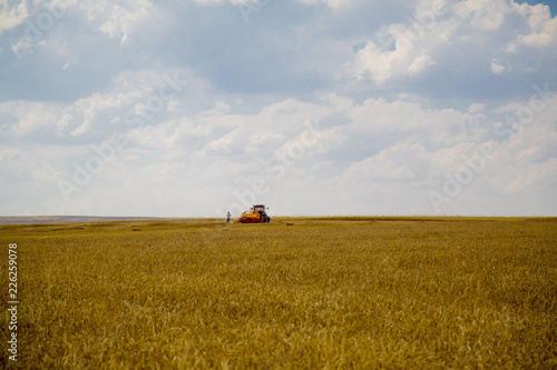 Combine harvester on a wheat field with blue sky photo