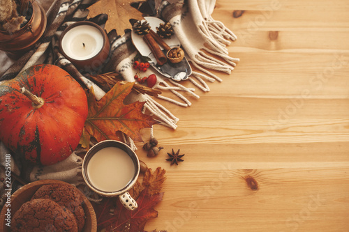 Autumn Flat Lay. Pumpkin,coffee,candle,fall leaves, cookies,berries,nuts,acorns on rustic blanket and wood background top view. Seasons greetings. Space for text. Happy Thanksgiving