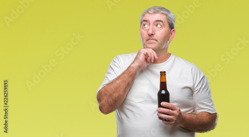 Handsome senior man drinking beer bottle over isolated background serious face thinking about question, very confused idea
