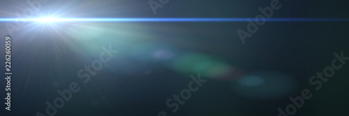 beautiful blue lens flare effect overlay texture with bokeh effect and anamorphic light streak in front of a black background, banner format