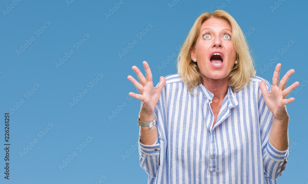 Middle age blonde business woman over isolated background crazy and mad shouting and yelling with aggressive expression and arms raised. Frustration concept. Middle age blonde business woman over isolated background crazy and mad shouting and yelling with aggressive expression and arms raised. Frustration concept.