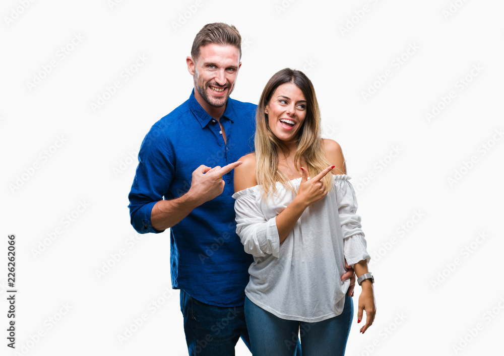 Young couple in love over isolated background cheerful with a smile of face pointing with hand and finger up to the side with happy and natural expression on face looking at the camera. Young couple in love over isolated background cheerful with a smile of face pointing with hand and finger up to the side with happy and natural expression on face looking at the camera.