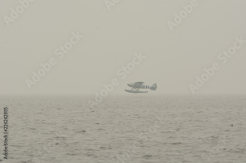 Float plane coming in for a smoky landing.