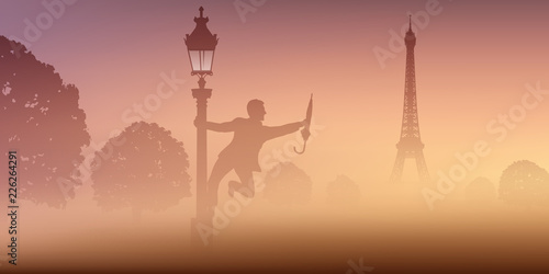 Un homme danse avec un parapluie, autour d'un lampadaire, devant la tour Eiffel à Paris.