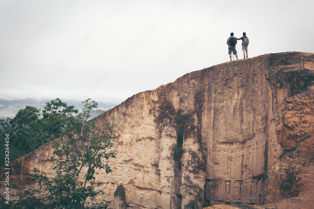 couple man and woman tourist at top of mountain outdoors during a hike in summer