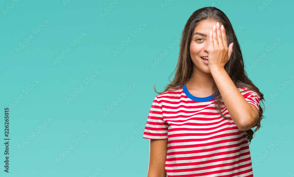 Young beautiful arab woman over isolated background covering one eye with hand with confident smile on face and surprise emotion. Young beautiful arab woman over isolated background covering one eye with hand with confident smile on face and surprise emotion.