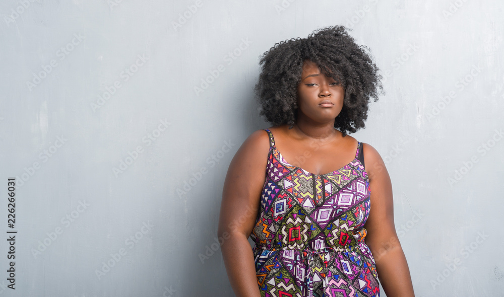 Φωτογραφία Young african american woman over grey grunge wall wearing colorful dress depressed and worry for distress, crying angry and afraid