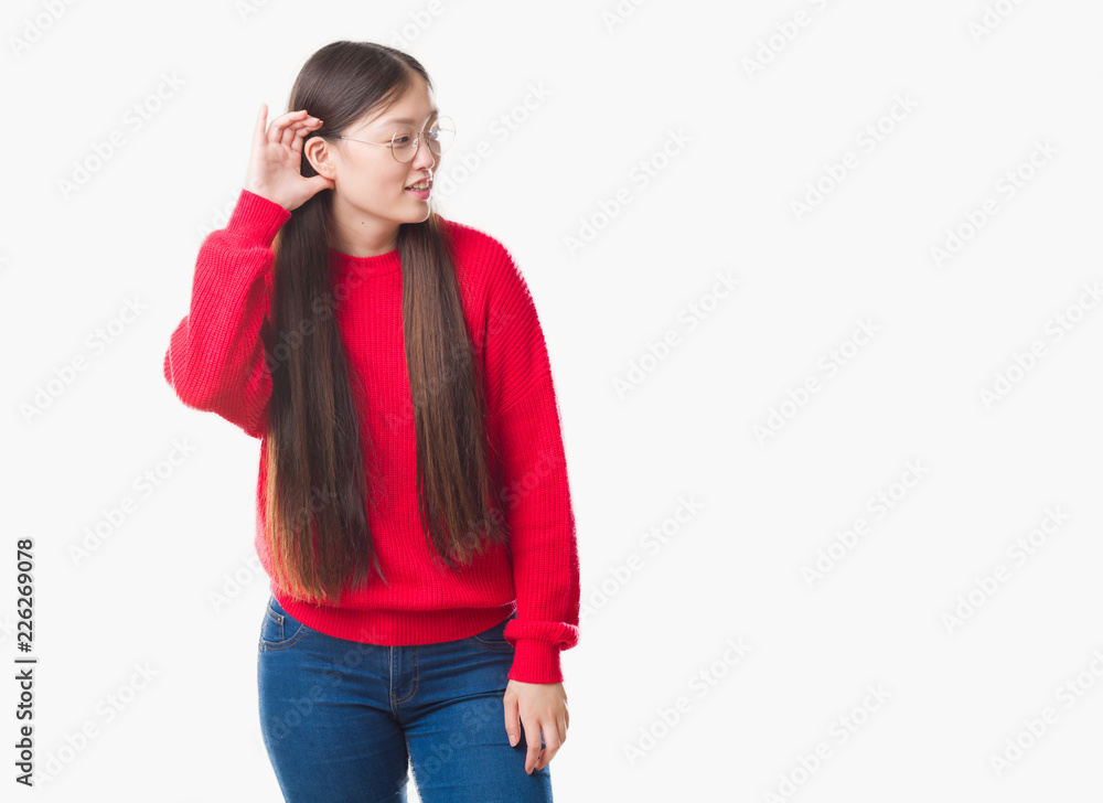 Young Chinese woman over isolated background wearing glasses smiling with hand over ear listening an hearing to rumor or gossip. Deafness concept. Young Chinese woman over isolated background wearing glasses smiling with hand over ear listening an hearing to rumor or gossip. Deafness concept.