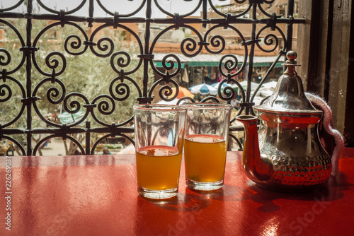 A couple of glasses of sweet mint tea with the teapot, in the table of a coffee shop in Marrakesh, Morocco.
