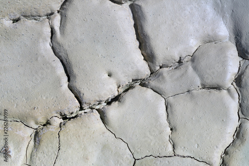 Light gray dry cracked surface of volcanic earth turned into desert
