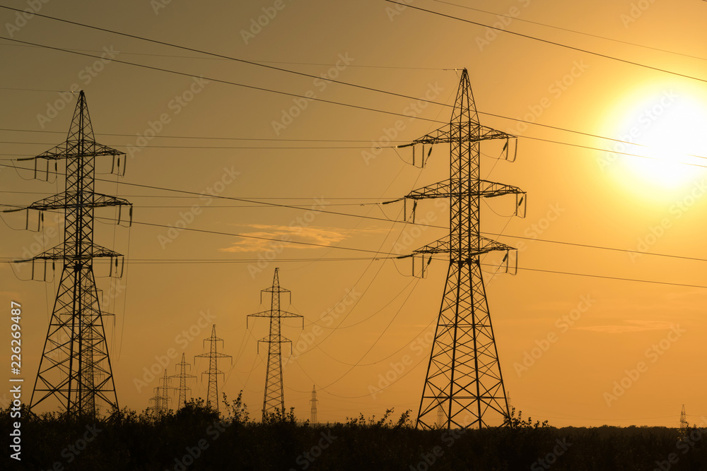 High voltage transmission lines at sunset. Energy and electrification