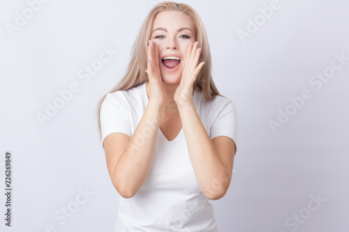 Woman in white shirt screaming on grey background