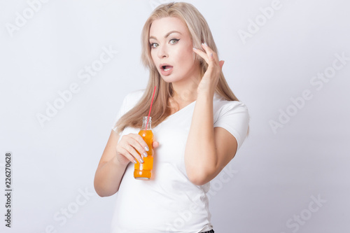 Blonde woman with orange soda in her hands