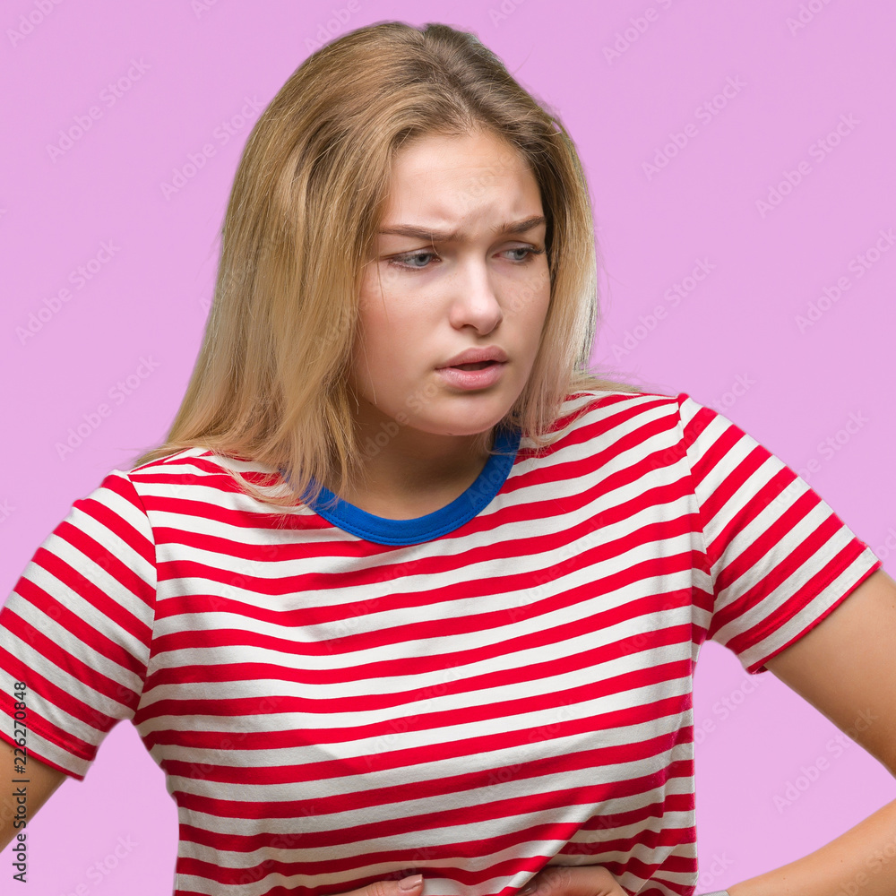 Young caucasian woman over isolated background with hand on stomach because indigestion, painful illness feeling unwell. Ache concept. Young caucasian woman over isolated background with hand on stomach because indigestion, painful illness feeling unwell. Ache concept.