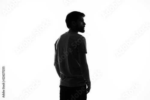 dark silhouette of a young man on a light background © SHOTPRIME STUDIO