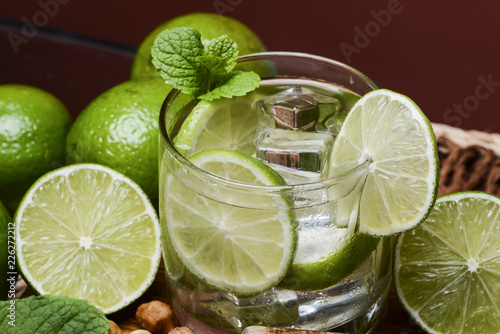 Refreshing cocktail with green lemon and ice.