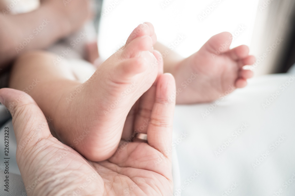 close up of father hand hold baby foot, Concept of love, family, relation close up of father hand hold baby foot, Concept of love, family, relation
