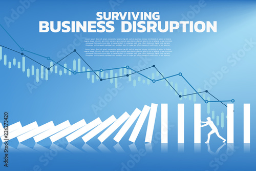 Silhouette of businessman pushing for stop falling of domino. business concept of try to stop the domino effect 