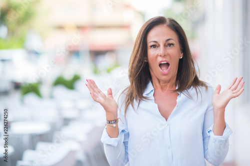 Wallpaper Mural Beautiful middle age hispanic woman at the city street on a sunny day very happy and excited, winner expression celebrating victory screaming with big smile and raised hands Torontodigital.ca
