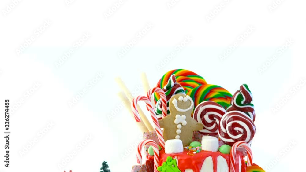 On trend festive candyland Christmas drip cake on white background. On trend festive candyland Christmas drip cake on white background.
