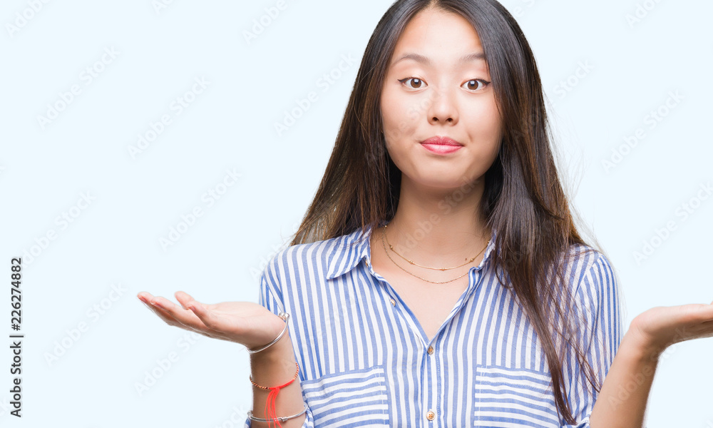 Young asian woman over isolated background clueless and confused expression with arms and hands raised. Doubt concept. Young asian woman over isolated background clueless and confused expression with arms and hands raised. Doubt concept.