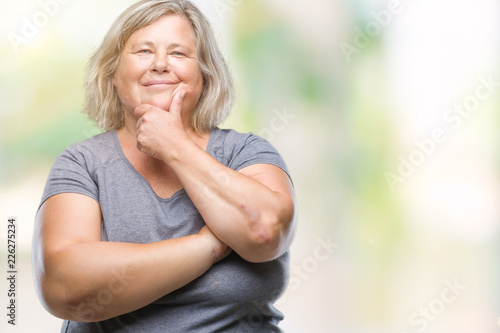 Senior plus size caucasian woman over isolated background looking confident at the camera with smile with crossed arms and hand raised on chin. Thinking positive.