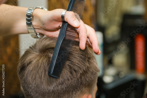 Scissor the hair of a man in a barbershop