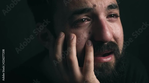 depression,sadness, melanchony. Bearded man crying in the dark- close up photo