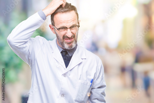Middle age senior hoary professional man wearing white coat over isolated background confuse and wonder about question. Uncertain with doubt, thinking with hand on head. Pensive concept.
