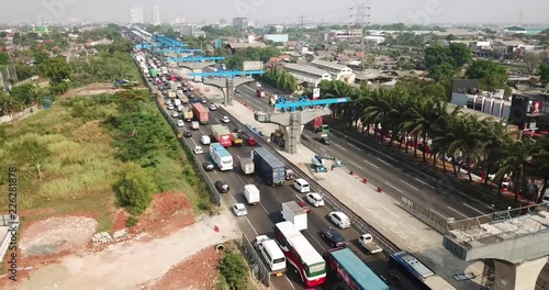 West Java, Indonesia - October 03, 2018: Aerial view of cars on the traffic jam in Jakarta-Cikampek toll road with columns of elevated toll road project. Shot in 4k resolution photo