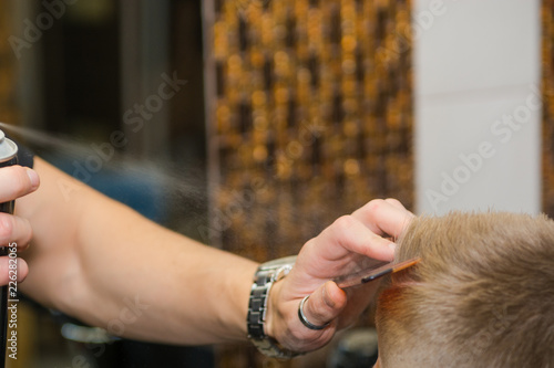 Spray hairspray man in a beauty salon